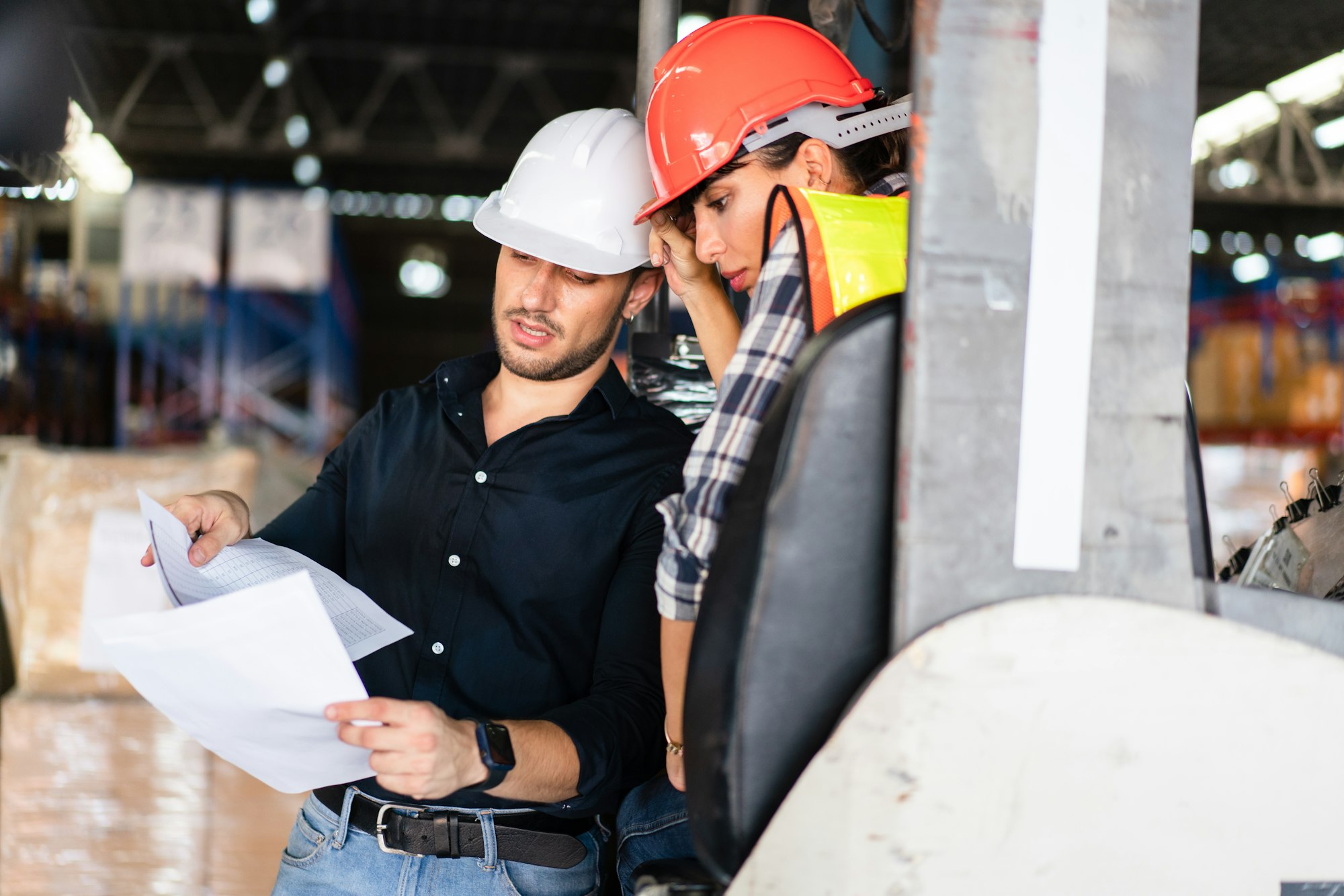 Factory foreman holding document discuss and explain work project to colleague Factory foreman holding document discuss and explain work project to colleague
