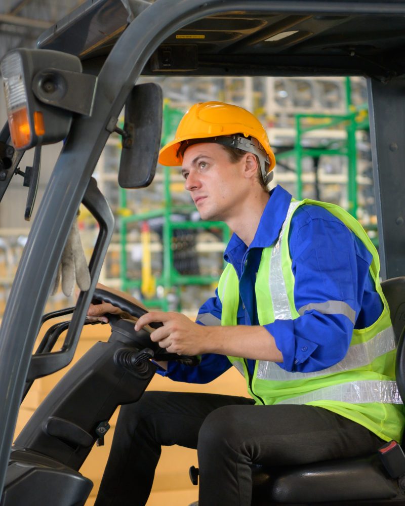 Worker in auto parts warehouse use a forklift to work to bring the box of auto parts into the storage shelf of the warehouse waiting for delivery to the car assembly line