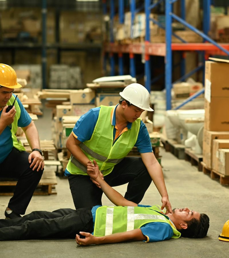 Shot of warehouse workers are helping and giving the injured first aid. Shot of warehouse workers are helping and giving the injured first aid.
