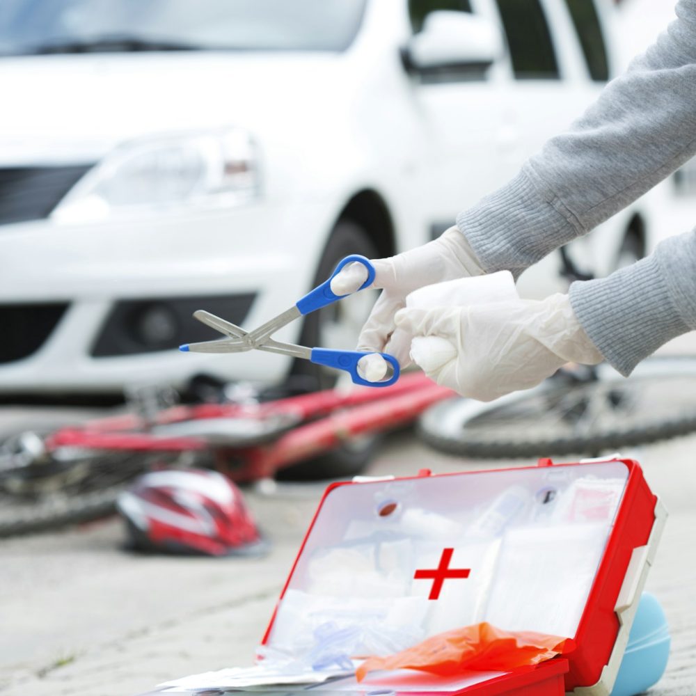 Woman applying first aid at crash scene, partial view Woman applying first aid at crash scene, partial view